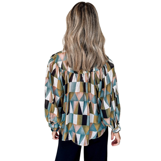 Woman wearing a geometric patterned blouse on a white background