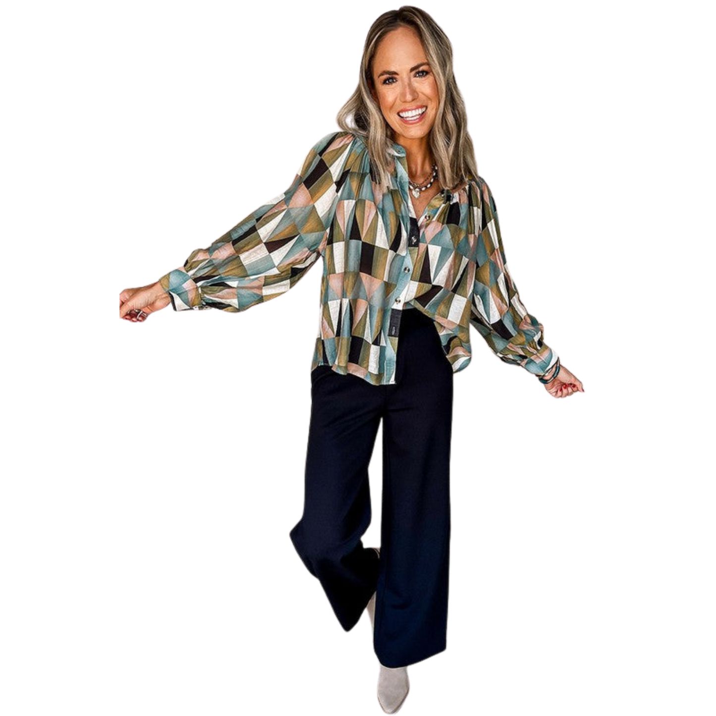Woman wearing a patterned blouse and dark pants on a white background