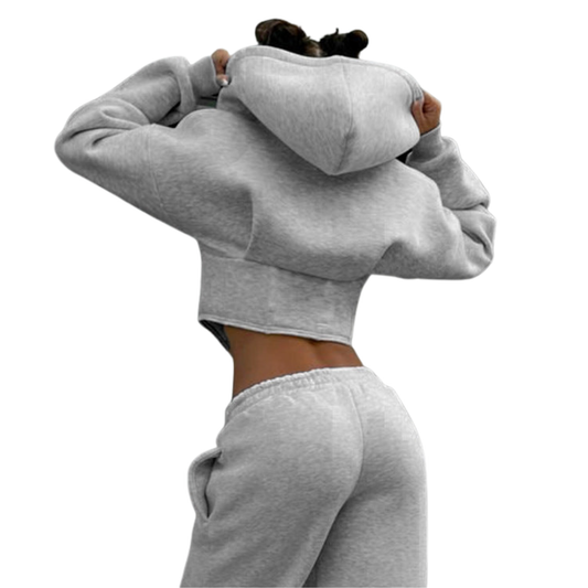 Person wearing a gray hoodie and matching pants on a white background