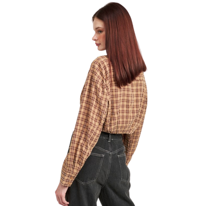 Woman wearing a plaid shirt and dark jeans on a white background