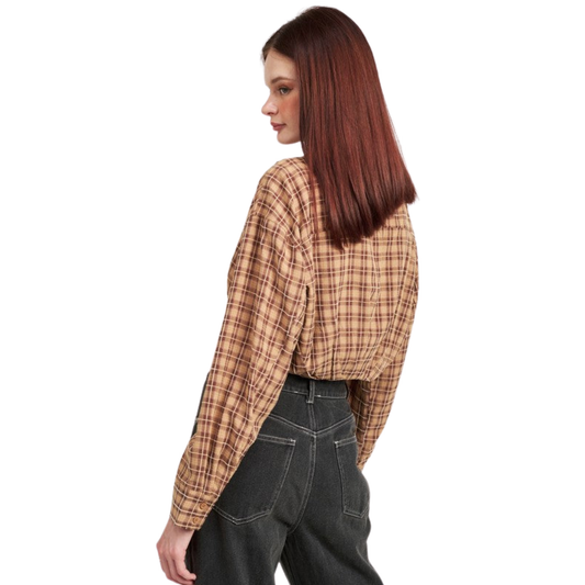 Woman wearing a plaid shirt and dark jeans on a white background