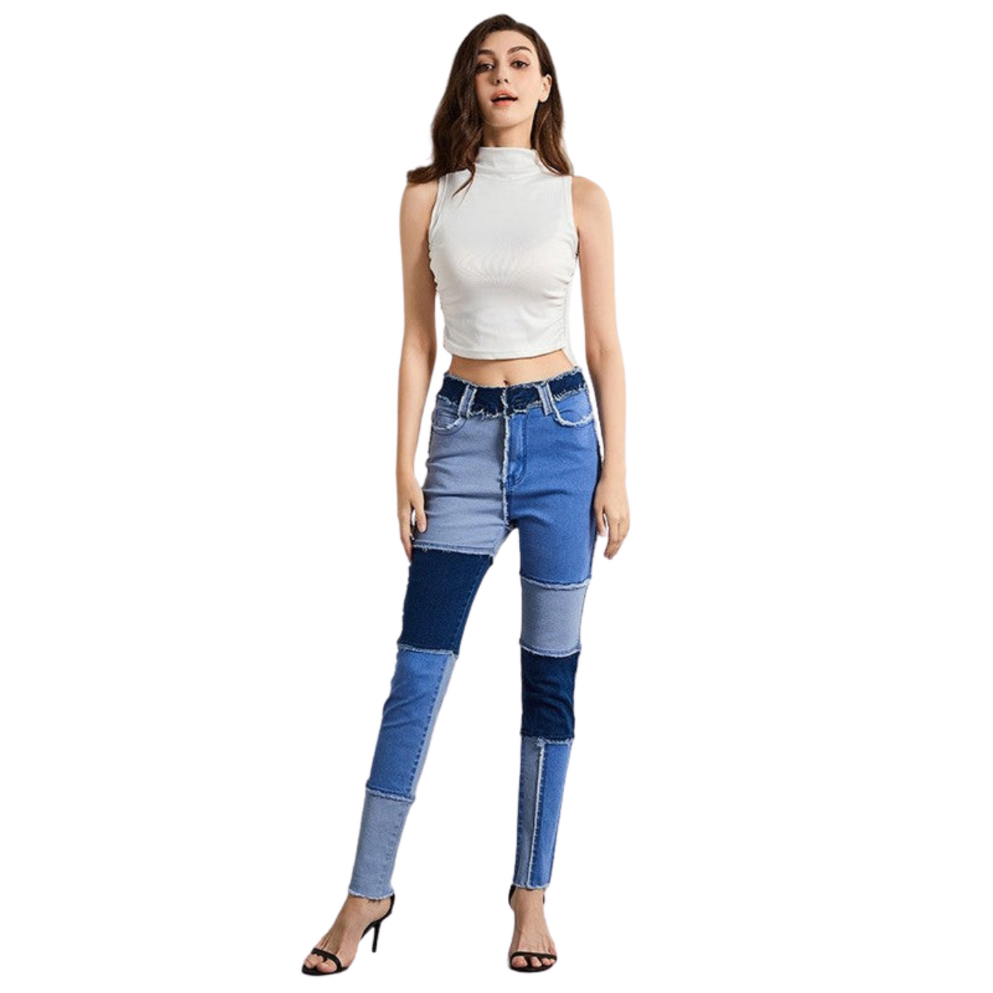 Woman wearing a white sleeveless top and blue patchwork jeans on a white background