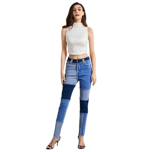 Woman wearing a white sleeveless top and blue patchwork jeans on a white background