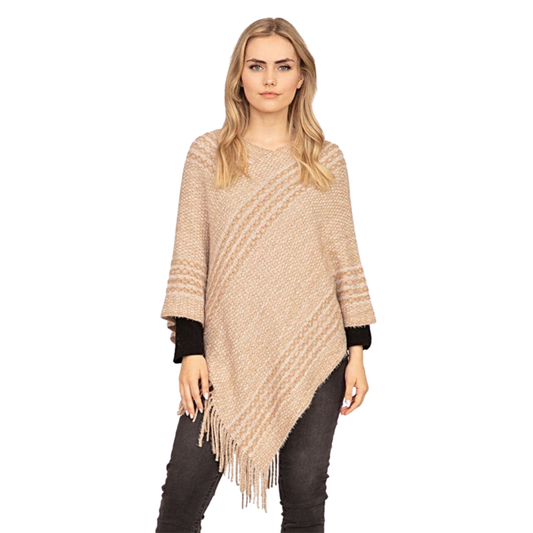 Woman wearing a beige poncho with fringe on a white background